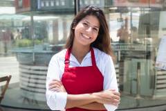 Foto: Junge Kellnerin vor dem Restaurant